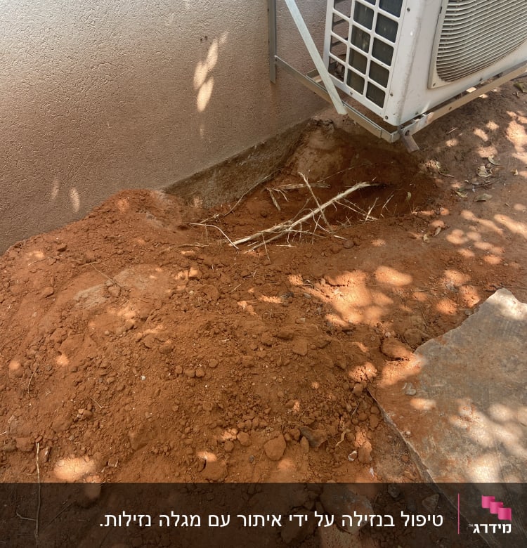 אדמה חפורה ליד קיר עם יחידת מיזוג אוויר